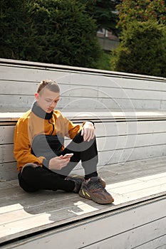 Teenage boy in anorak jacket using mobile phone