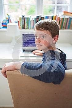 Teenage Boy In Bedroom Writing Computer Code