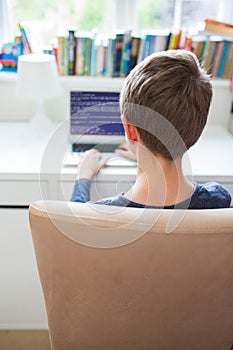 Teenage Boy In Bedroom Writing Computer Code