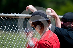 Teenage boy from behind looking through fence.