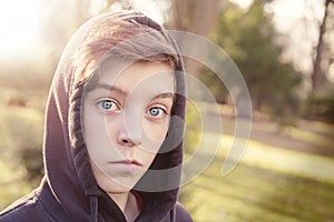 Teenage boy with black hoodie in a park