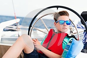 Teenage boy on board of sailing yacht