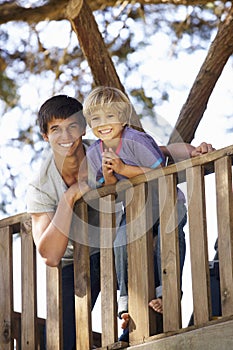 Teenage Boy And Brother Playing In Tree House Together