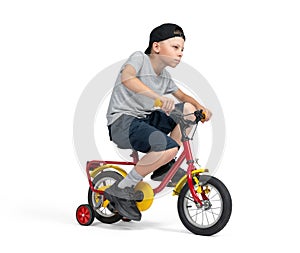 A teenage boy, in a cap, T-shirt, shorts, excitedly rides a children's bike, isolated on a white