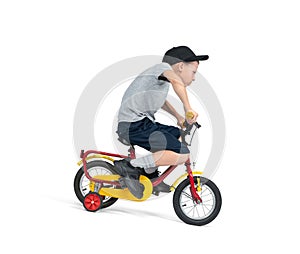 A teenage boy, in a cap, T-shirt, shorts, excitedly rides a children\'s bike, isolated on a white background.