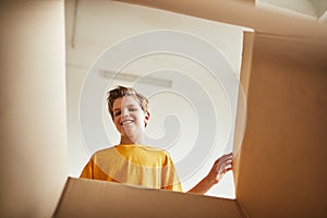 Teenage Boy Carrying Box in New House