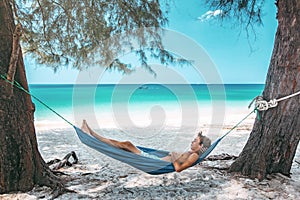 Teenage boy chilling in hammock on the beach