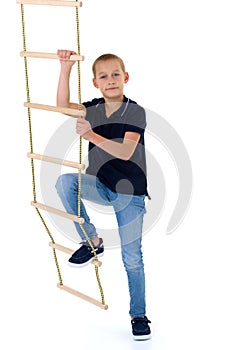 Teenage boy climbiing on rope ladder photo