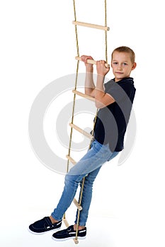 Teenage boy climbiing on rope ladder photo
