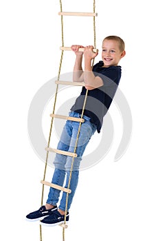 Teenage boy climbiing on rope ladder photo