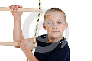 Teenage boy climbiing on rope ladder photo