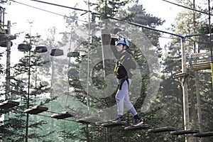 Teenage boy climbing at adventure park