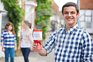 Teenage Boy Collecting For Charity In Street