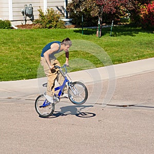 Teenage boy doing tricks on a BMX bike.