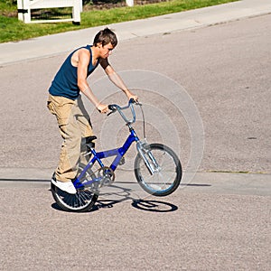 Teenage boy doing tricks on a BMX bike.