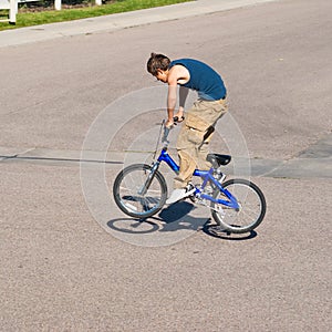 Teenage boy doing tricks on a BMX bike.