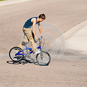 Teenage boy doing tricks on a BMX bike.