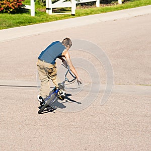 Teenage boy doing tricks on a BMX bike.