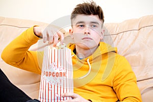 Teenage boy eating popcorn