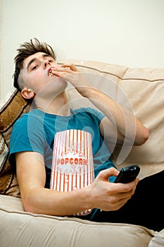 Teenage boy eating popcorn