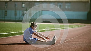 Teenage boy engaged in sport stadium stretching