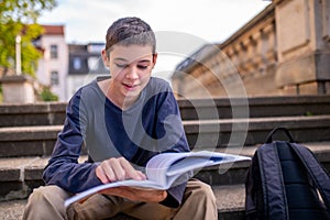 Teenage boy engrossed in reading a book