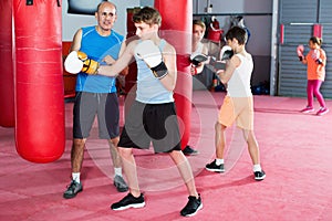 Teenage boy exercising at boxing at gym