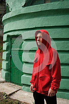 Teenage boy in fashionable red hoodie on street