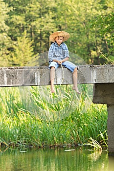 Teenage boy fishing with rod on bridge