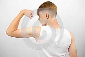 Teenage boy flexing from behind