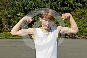 Teenage boy flexing his arm muscles