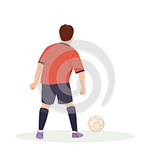 Teenage boy football player, in a red sports shirt, kicks a soccer ball. Kid sportsman playing football game, dynamic