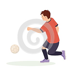 Teenage boy football player, in a red sports shirt, kicks a soccer ball. Kid sportsman playing football game, dynamic