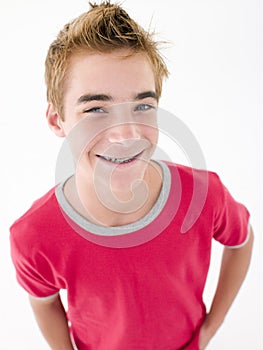 Teenage boy with hands in pockets smiling