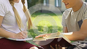 Teenage boy helping girl with homework, trying to kiss, adolescence and hormones