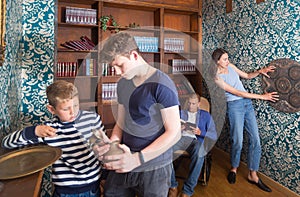 Two teen brothers examining ancient kettle in quest room