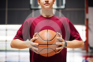 Teenage boy holding a basketball on the court photo