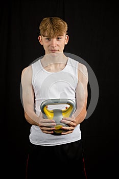 Teenage boy holding a kettlebell