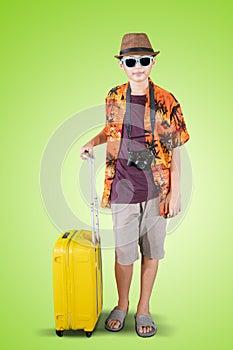 Teenage boy holding a luggage in the studio