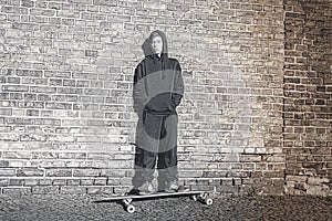 Teenage boy with hoodie standing on a long board