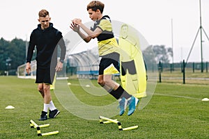 Teenage boy jumping over hurdles. Young soccer athlete practicing strength and agility skills