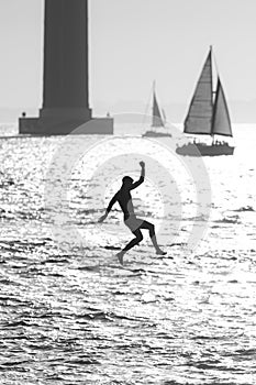 Teenage boy jumping in the water from a pier - black and white image