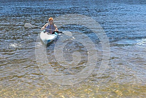 Teenage boy in a kayak on a lake in summer