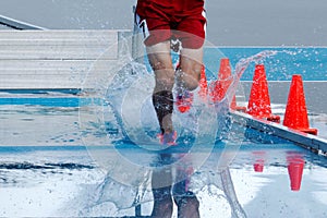Teenage boy lands in water during a steeplechase race