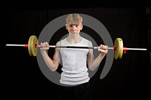 Teenage boy lifting a barbell