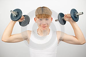 Teenage boy lifting dumbbells