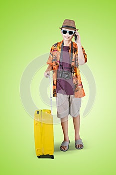 Teenage boy with luggage and phone on studio