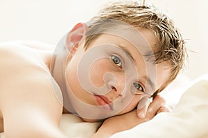 Teenage Boy Lying on Bed with Head on Hands