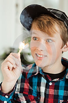 Teenage Boy Mesmerized by Flame of Lit Match
