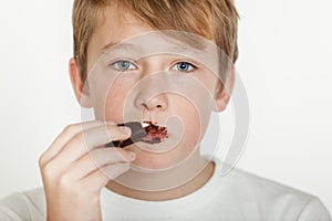 Teenage Boy with Messy Face Eating Chocolate